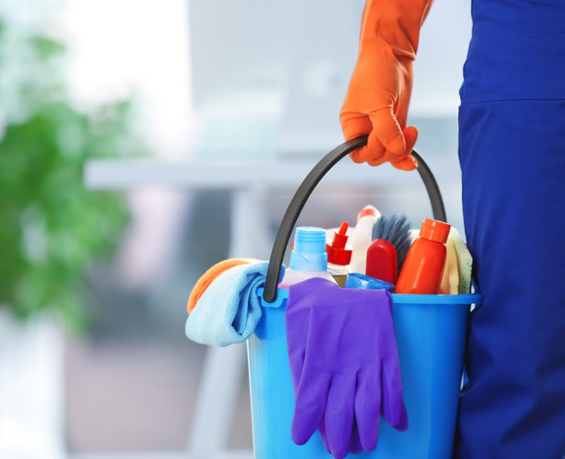 holding cleaning products and tools on bucket, close up